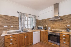 A kitchen with wooden cabinets, a stainless steel sink, a microwave, and a dishwasher.