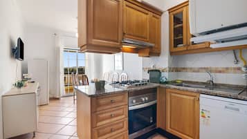 Eine Küche mit Holzausstattung, einem Backofen, einem Gasherd und einem Geschirrspüler.