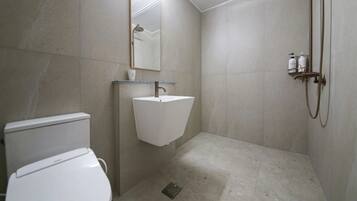 Een badkamer met toilet, wastafel, douche en spiegel.