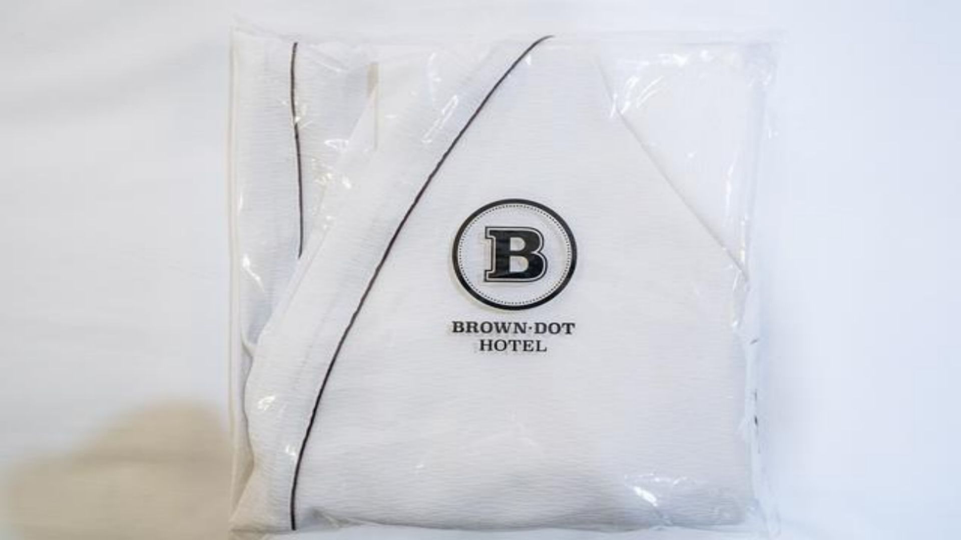 A pillow with a logo and text indicating it is from the Brown-Dot Hotel.