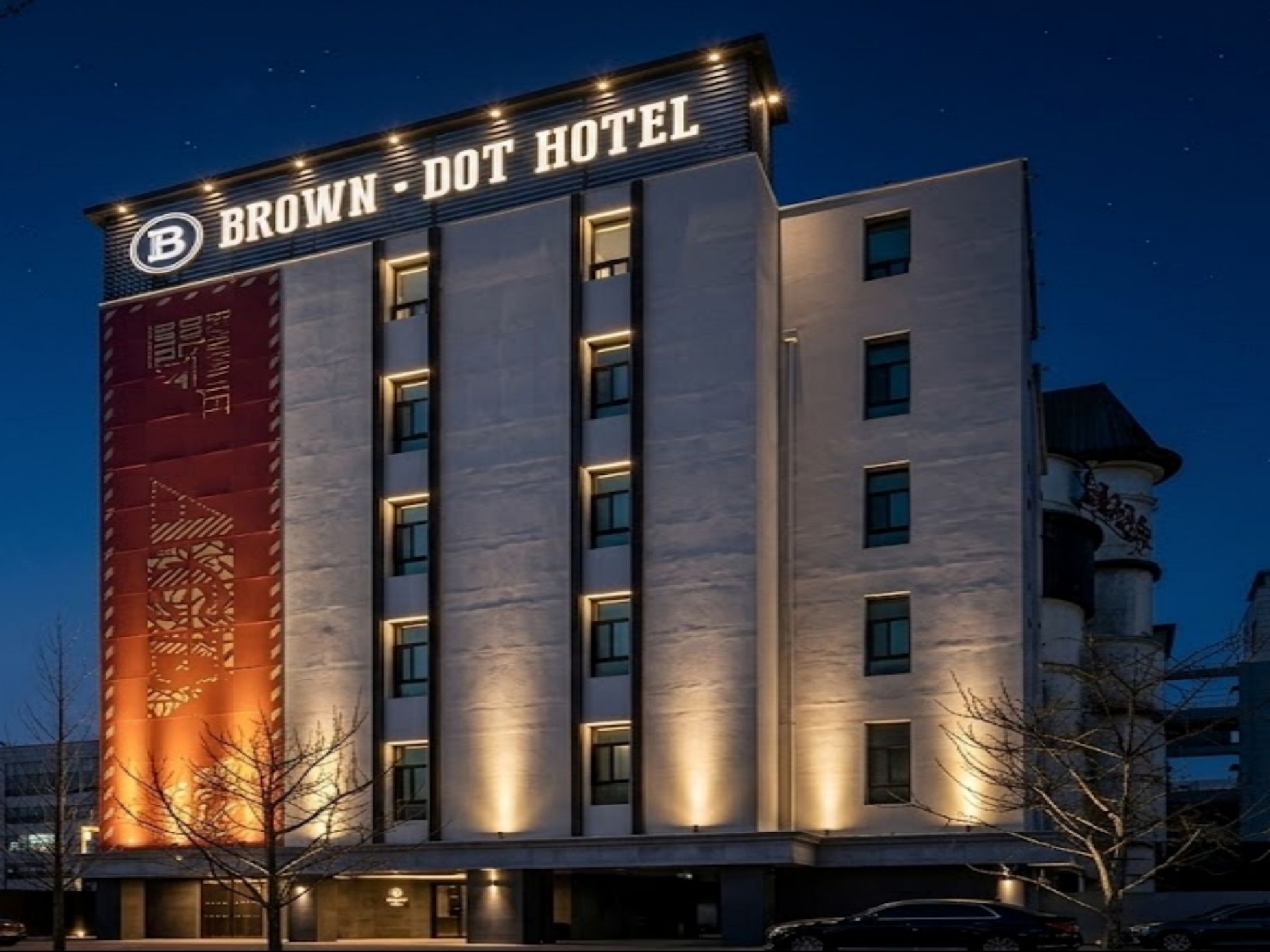 Et hotel med flere etager, med et tydeligt skilt der viser 'BROWN DOT HOTEL'.