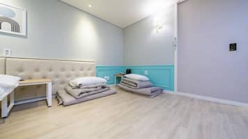 Una habitación de hotel con una cama, una mesita de noche, una lámpara y una luz empotrada en la pared.