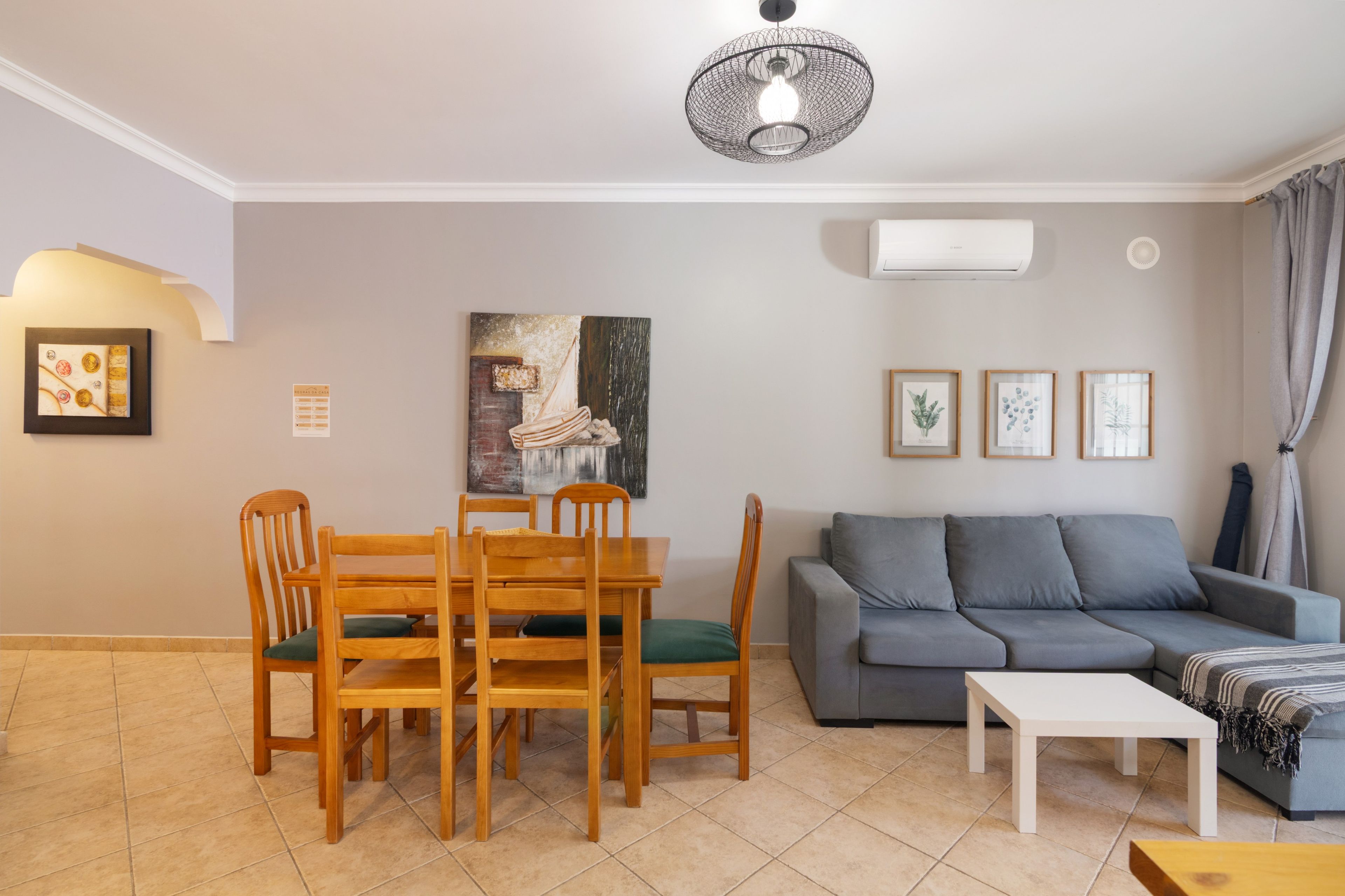 A living room with a dining table, chairs, a sofa, and a coffee table.