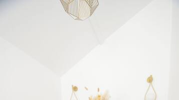 Un coin repas avec une table ronde, quatre chaises et un vase contenant des fleurs séchées.