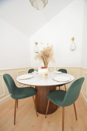 A dining area with a round table, four chairs, and a vase with dried flowers. - Fabuleuse maison de campagne avec jardin proche Thoiry, Versailles (Auteuil)