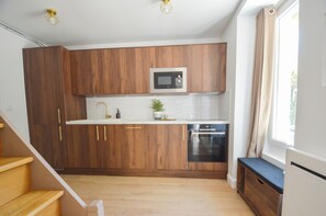 Una cocina funcional con armarios de madera, microondas y lavavajillas.