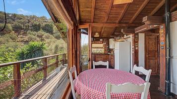 Een houten chalet met een balkon dat uitkijkt over een bergachtig landschap.