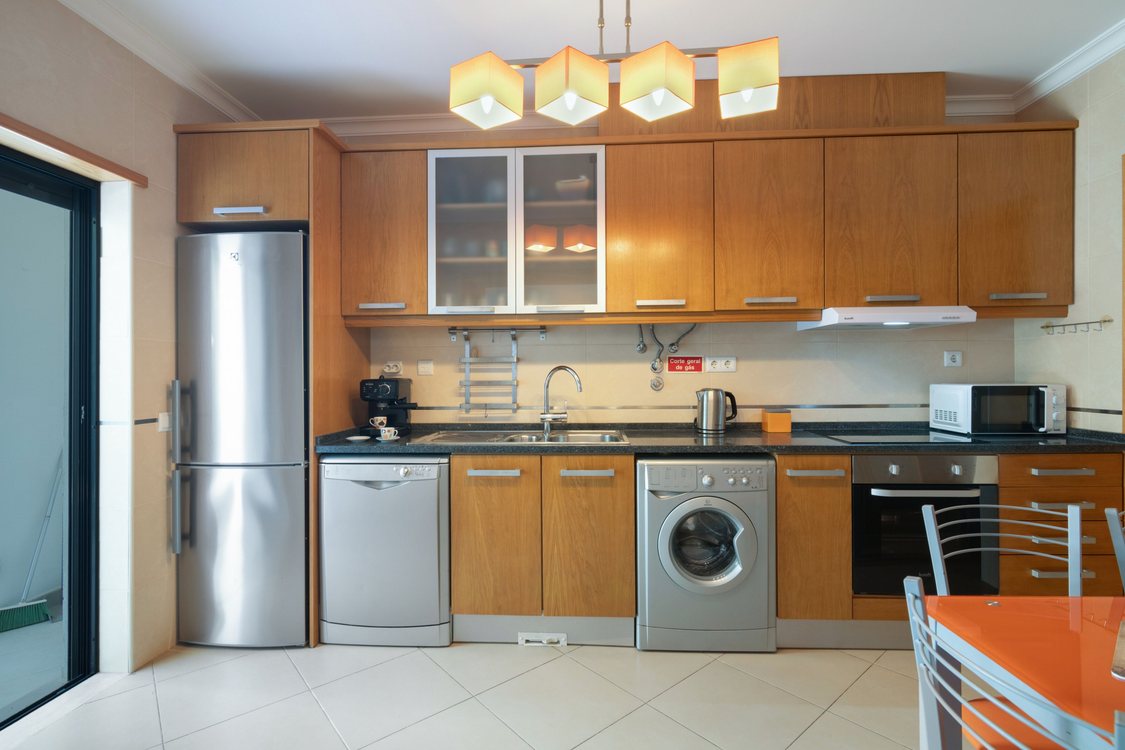 A modern kitchen with stainless steel appliances, wooden cabinets, and a built-in oven.