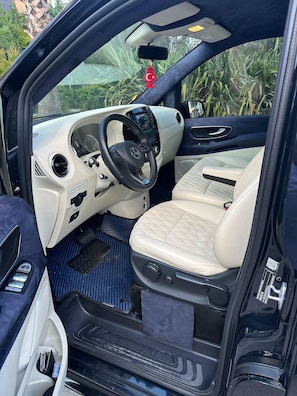 A car interior with a steering wheel, dashboard, and beige seats. - otel (Ankara)