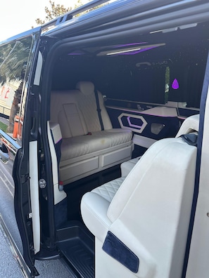 A vehicle interior with a bench seat, a foldable table, and a storage compartment. - otel (Ankara)