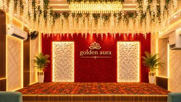 A stage with a red floral backdrop and a chandelier, labeled 'golden aura.'