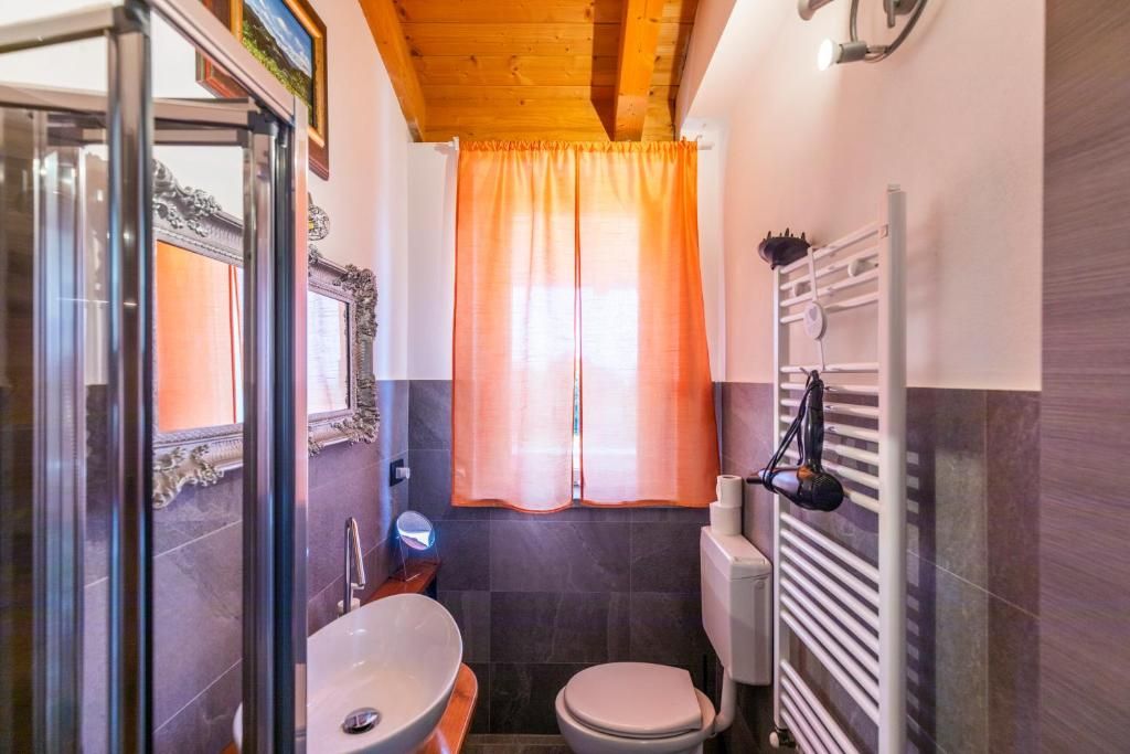 Une salle de bain avec une douche à parois de verre, un lavabo, des toilettes et un porte-serviettes.