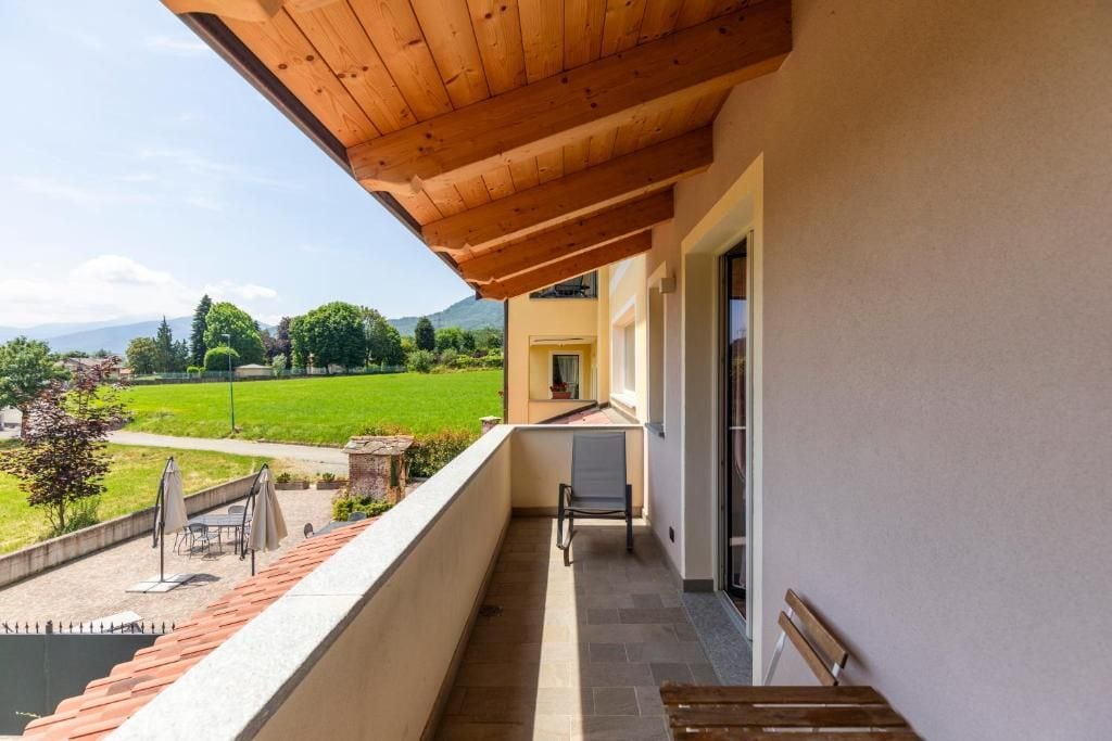 Ein Balkon mit Holzboden, einem Stuhl und einem Tisch.