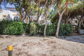 A paved courtyard with trees and a building with multiple windows. - Apartment 'Real Village' with Private Terrace, Wi-Fi and Air Conditioning (Altura)