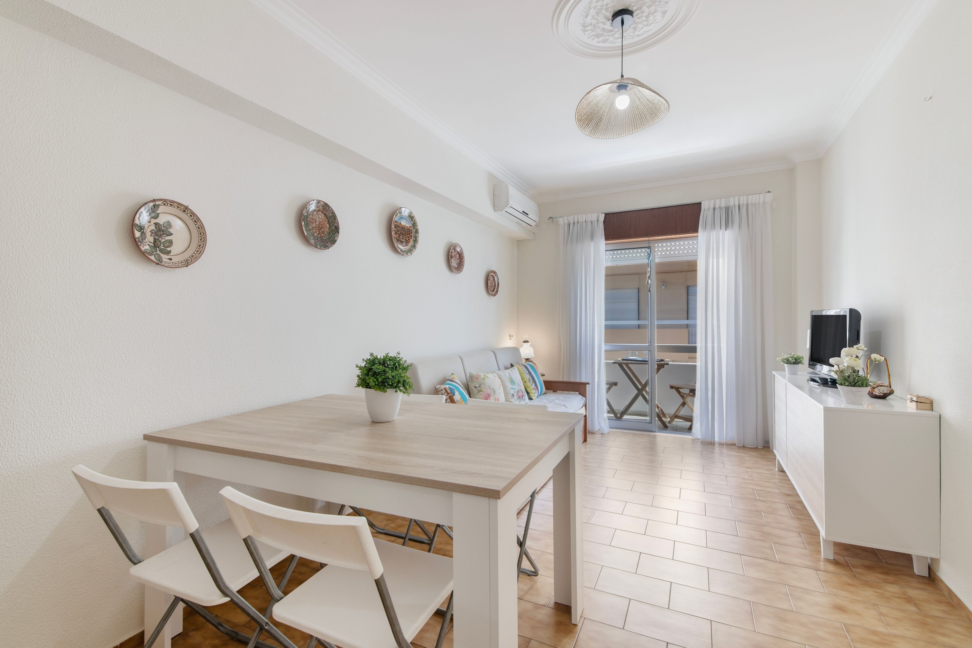 Una cocina moderna con una mesa de comedor, sillas y una planta en maceta.