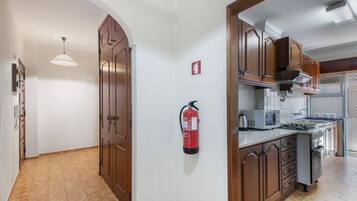 Une cuisine avec des meubles en bois, une cuisinière à gaz et un four à micro-ondes.