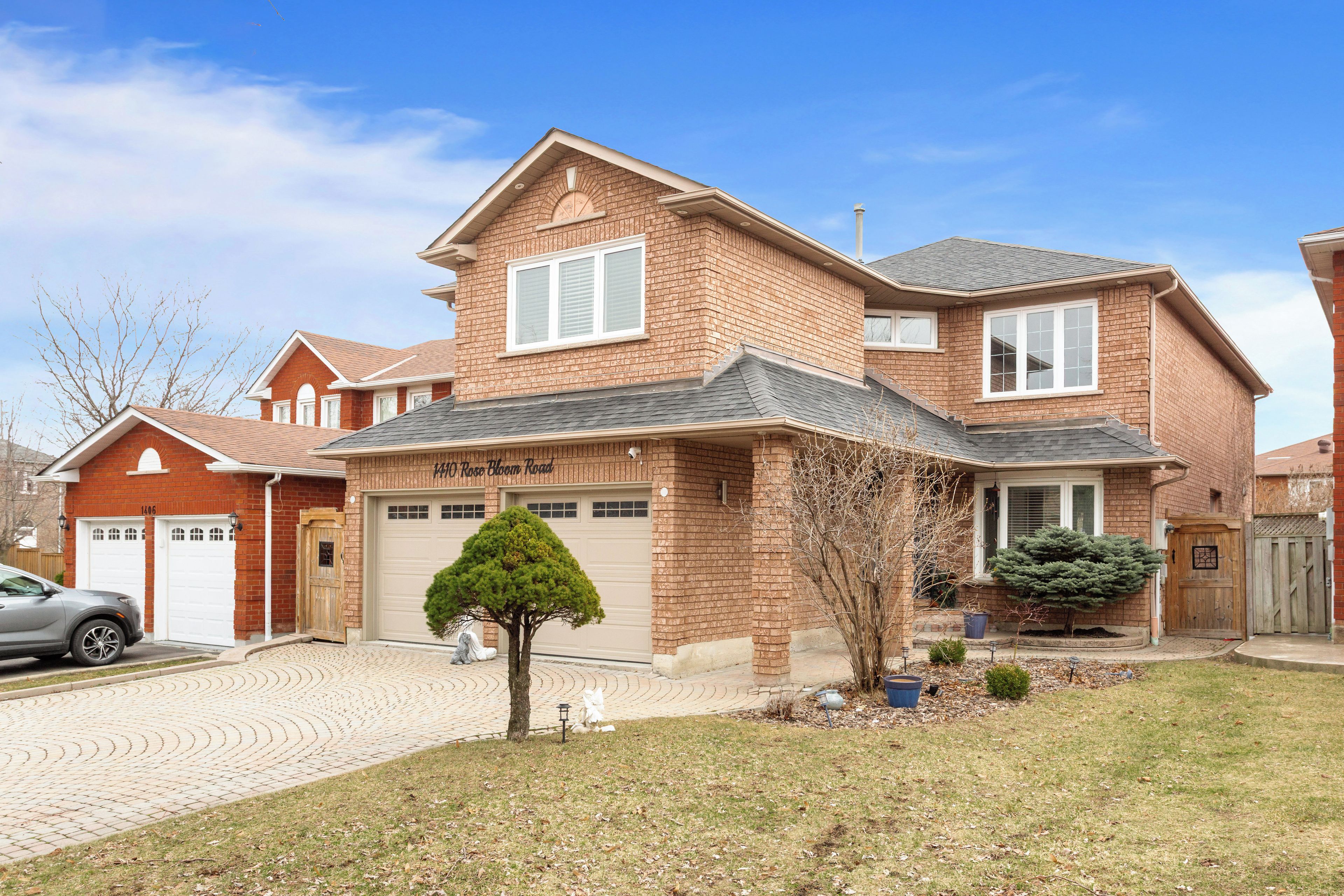 A two-story house with a garage, a driveway, and a well-maintained lawn.