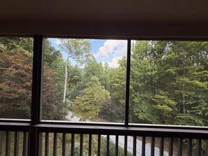 A window with a view of a forested area. - Highlands Mountain Hideaway. Views, Fireplace & Minutes to Downtown. (Highlands)