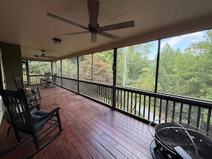 A covered porch with a ceiling fan, a rocking chair, and a grill. - Highlands Mountain Hideaway. Views, Fireplace & Minutes to Downtown. (Highlands)
