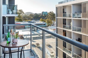 A balcony with a table, chairs, and a bottle of champagne. - Fantastic 3-bedroom apartment with AC in charming West End (West End)
