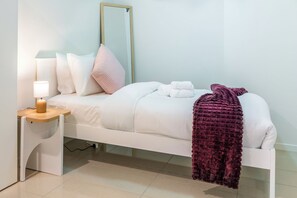 A bedroom with a bed, a bedside table with a lamp, a mirror, and a blanket. - Fantastic 3-bedroom apartment with AC in charming West End (West End)