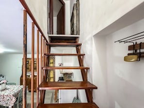 A wooden staircase with a metal handrail and a wall-mounted rack with dishes. - The Lucretili's Shelters - Orazio's Land (Licenza)