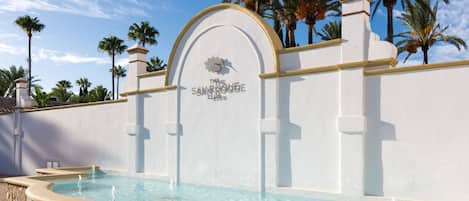 A pool area with a sign reading 'The Sand Rose Club.'