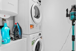 A front-loading washing machine with a front control panel and a water inlet. - EMERALD GREEN 2477 SAN ROQUE (San Roque)
