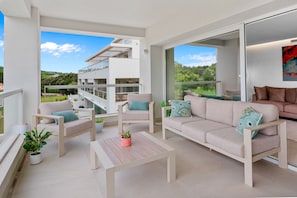 A modern outdoor living space with a sofa, chairs, and a table. - EMERALD GREEN 2477 SAN ROQUE (San Roque)