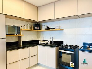 A modern kitchen with a microwave, coffee maker, and oven.