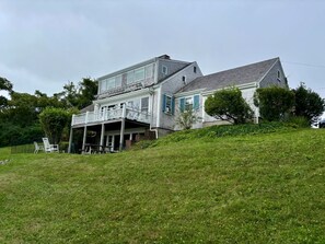 Ein zweistöckiges Haus mit einer Veranda und einem überdachten Eingangsbereich.