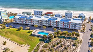 Ein Strandhotel mit mehreren Gebäuden, einem Schwimmbad und Blick auf den Strand.
