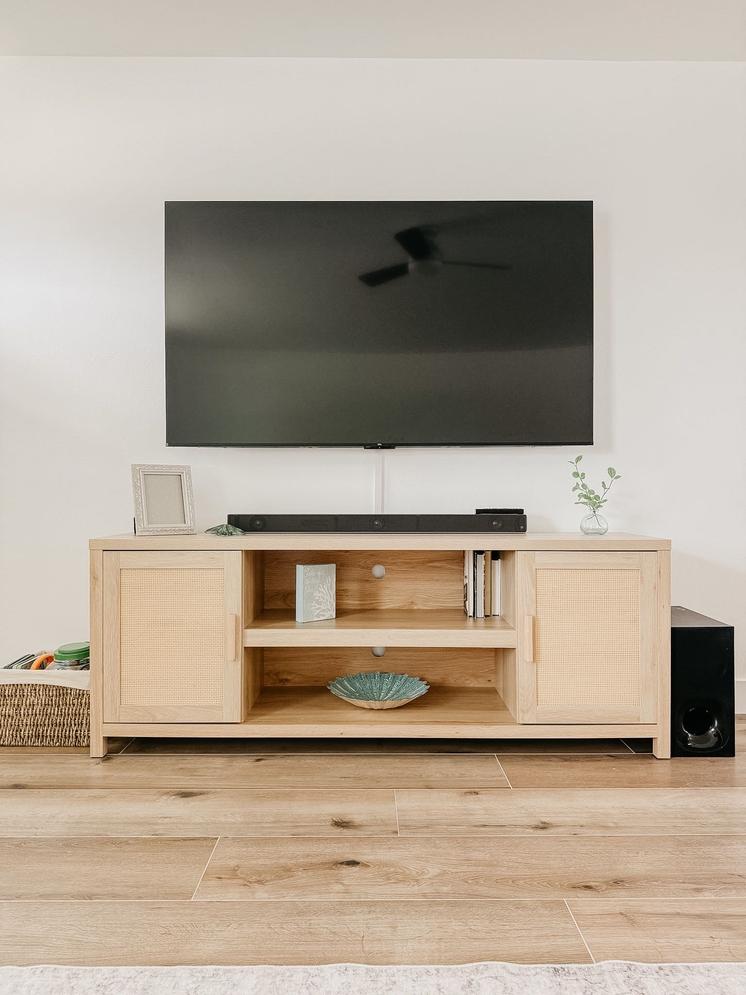 Un mueble de madera para entretenimiento con un televisor de pantalla plana montado encima.