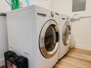A front-loading washing machine with a control panel, a black Craftsman power tool case, and a green bottle on top. - Punta Gorda Waterfront Escape, Private Pool, Gulf Access, 3BR, Near Downtown (Punta Gorda)