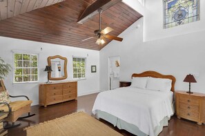 A bedroom with a wooden ceiling, a large bed, two nightstands, a dresser, and a mirror. - Tropical Hideaway - Private Pool (Key West)
