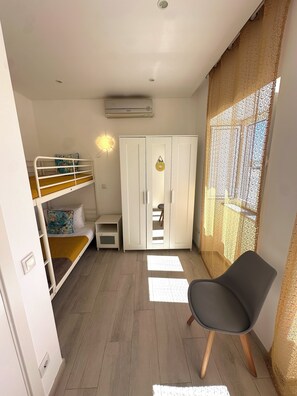 A room with bunk beds, a wardrobe, a chair, and a window with a view. - House of Saint Lucy! With a View of the Ria Formosa! (Santa Luzia)