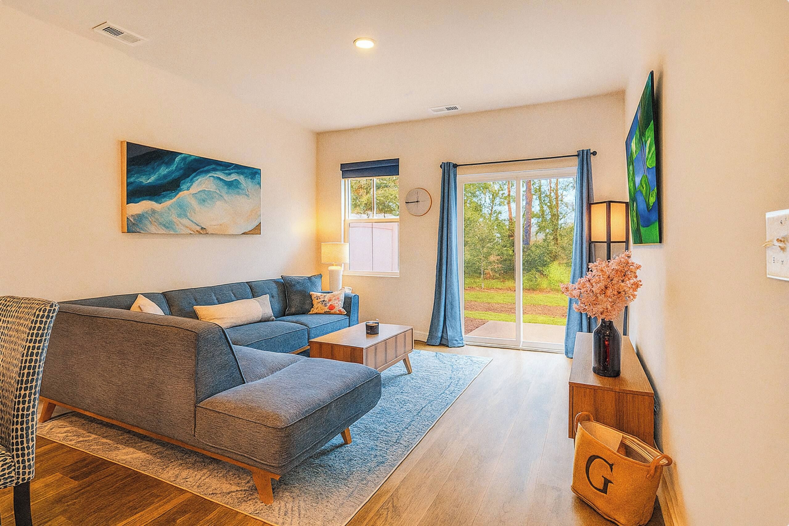 A modern living room with a sofa, coffee table, and a painting on the wall.