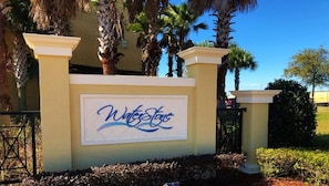 A sign with the name 'WaterStone' in stylized lettering, set against a beige wall with decorative pillars. - Waterstone Paradise | Your 5 star Florida Stay (Davenport)
