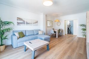 A modern living room with a sofa, coffee table, and dining area. - Cubo's Suite Sol Fuengirola Apartment / center / air conditioning / free wifi (Fuengirola)