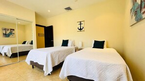 A hotel room with two beds, a mirror, and a wall-mounted anchor decoration. - 3BR Condo With Pool Near Los Sueños, Herradura (Jacó)