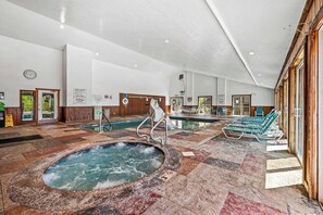 An indoor swimming pool area with a hot tub, lounge chairs, and a clock on the wall. - Panoramic Smoky Mountain Views, Indoor Pool, 2 BD (Gatlinburg)