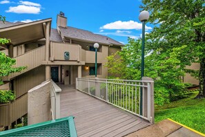 A multi-story building with a covered walkway leading to the entrance. - Panoramic Smoky Mountain Views, Indoor Pool, 2 BD (Gatlinburg)