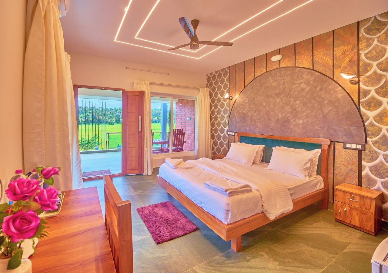 A bedroom with a bed, bedside table, and a view of the outside.