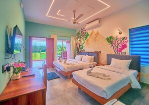 Une chambre d’hôtel avec deux lits, un bureau, une télévision et un balcon avec vue.
