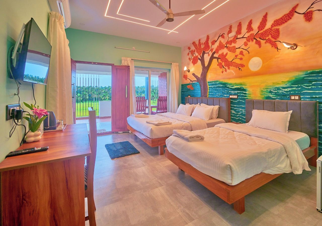 Habitación de hotel con dos camas, un escritorio, un televisor y vistas al exterior.