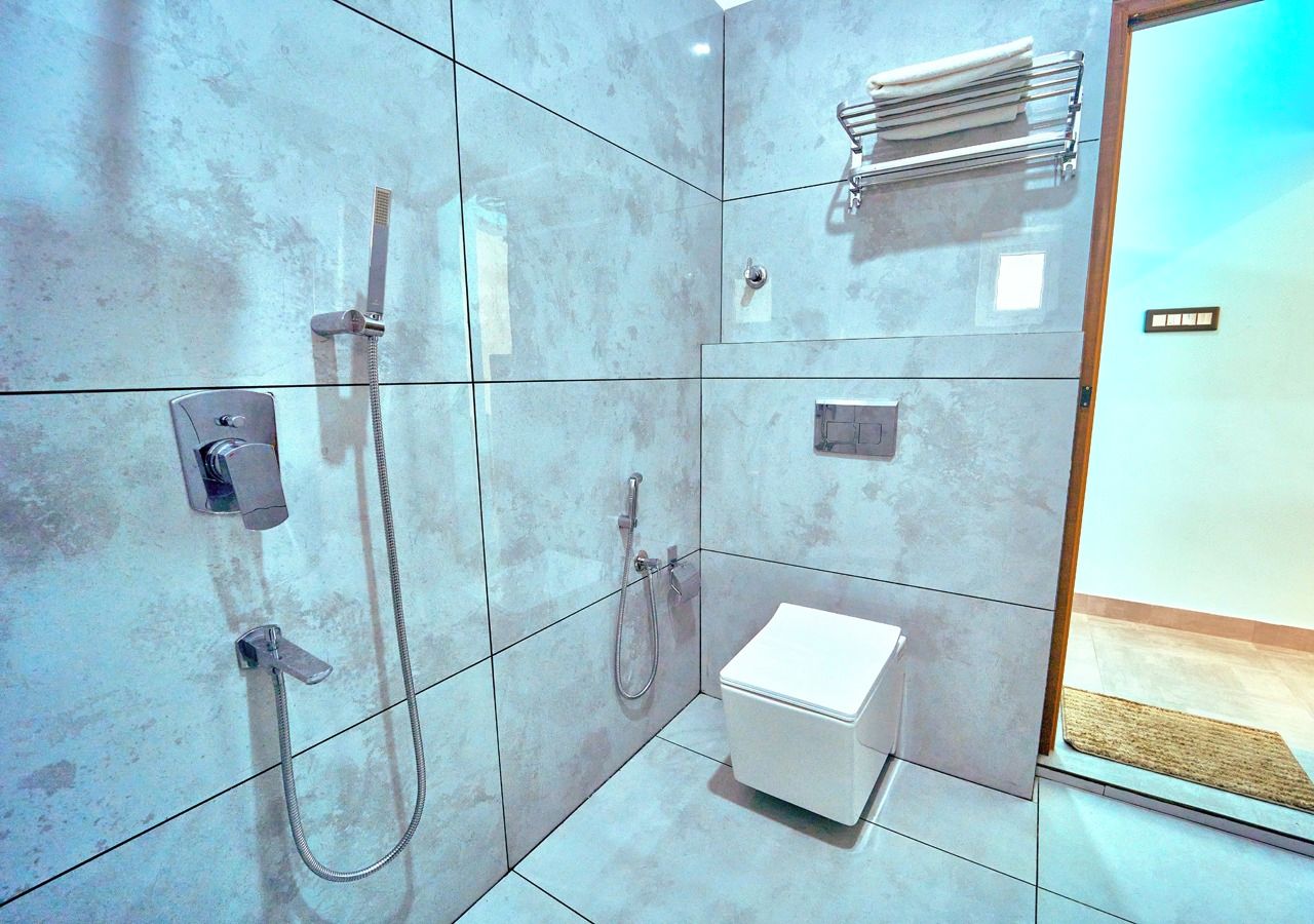 A modern bathroom with a shower, toilet, and towel rack.