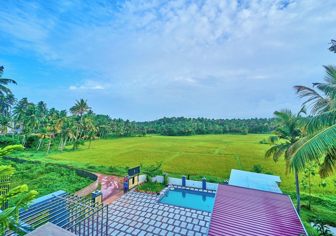 A view of a green field with a building in the foreground.