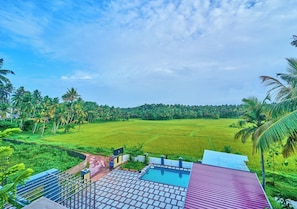 A view of a green field with a building in the foreground.