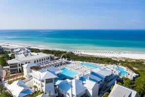 Ein Resort mit mehreren Gebäuden, einem großen Poolbereich und einem Strand.