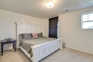 A bedroom with a bed, a nightstand, a window, and a ceiling light. - New-build Townhome Near Speedway & Uncc (Charlotte)